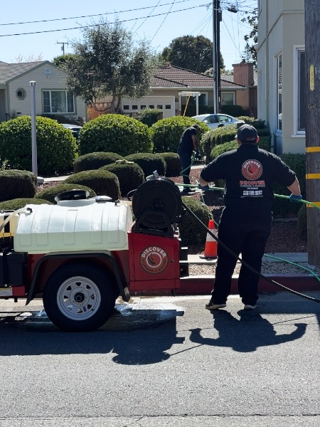 A DiscoverPlumbing&Rooter technician working with equipment on a residential street in San Francisco, focusing on plumbing maintenance.